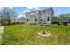 Spacious backyard featuring lush lawn, mature trees, fire pit, and a patio area at 708 Teal Cir, Longmont, CO 80503