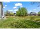 A spacious backyard with a wooden fence, lush green grass, and mature trees at 708 Teal Cir, Longmont, CO 80503