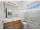 Bathroom with a wood vanity, large mirror and tiled shower with glass doors at 708 Teal Cir, Longmont, CO 80503
