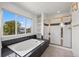 Bright bathroom with a large tub, a separate shower and a view of the neighborhood at 708 Teal Cir, Longmont, CO 80503
