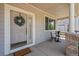Inviting front porch with a decorative wreath, seating area, and brick pillars, creating a cozy entrance at 708 Teal Cir, Longmont, CO 80503