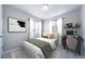 Modern bedroom with a neutral color palette, featuring a sleek desk and stylish decor at 46570 Avery Ln, Bennett, CO 80102