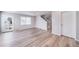 Open-concept living area with luxury vinyl plank flooring and staircase at 46570 Avery Ln, Bennett, CO 80102