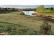 Expansive backyard featuring a serene pond and lush green space, perfect for outdoor enjoyment and relaxation at 6216 E 135Th Ave, Thornton, CO 80602