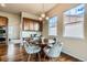 A bright dining area is adjacent to the kitchen with a round table and modern chandelier at 6216 E 135Th Ave, Thornton, CO 80602
