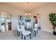 Elegant dining room featuring a glass table, seating for four, and stylish decor, adjacent to living spaces at 6216 E 135Th Ave, Thornton, CO 80602