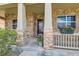 Close-up of a welcoming front porch with stone columns, windows, and decorative flower boxes, enhancing curb appeal at 6216 E 135Th Ave, Thornton, CO 80602