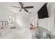 Spacious bedroom with a ceiling fan, large windows, and a modern TV mounted on the wall at 117 S Pierce St, Lakewood, CO 80226