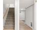 A carpeted stairway with a wooden handrail leads to the upper level, near a closet and a door at 117 S Pierce St, Lakewood, CO 80226