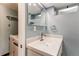 Bright bathroom with vanity, modern fixtures, mirror, and adjacent laundry machines at 17882 E Wyoming Pl, Aurora, CO 80017