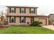Charming two-story home with brown siding, well-maintained lawn, and attached garage at 17882 E Wyoming Pl, Aurora, CO 80017