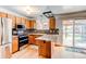 Well-lit kitchen with stainless steel appliances, tile backsplash, and wood cabinets at 17882 E Wyoming Pl, Aurora, CO 80017