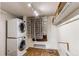 Laundry room featuring stacked washer and dryer with shelving and wood flooring at 17882 E Wyoming Pl, Aurora, CO 80017