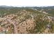 Sweeping aerial perspective of a charming mountain town, showcasing homes amid lush greenery at 3191 Bittersweet Ln, Evergreen, CO 80439