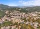 Expansive aerial image of a vibrant community nestled within rolling, tree-covered mountains at 3191 Bittersweet Ln, Evergreen, CO 80439