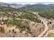 Stunning aerial view of a mountain community nestled among lush pine trees and rolling hills at 3191 Bittersweet Ln, Evergreen, CO 80439
