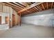 Unfinished basement area with exposed framing, carpet, and access to other rooms at 3191 Bittersweet Ln, Evergreen, CO 80439