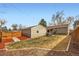 Fenced backyard featuring a hot tub, detached garage and covered deck area at 1801 S Meade St, Denver, CO 80219