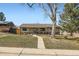 Inviting single-story home with a well-maintained lawn, mature trees, and a charming front porch at 1801 S Meade St, Denver, CO 80219