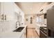 Bright kitchen featuring white cabinetry, stainless steel appliances, and updated countertops at 1801 S Meade St, Denver, CO 80219