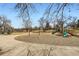Neighborhood playground with swings and slides surrounded by mature trees and accessible via paved walkway at 1801 S Meade St, Denver, CO 80219