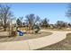 Community playground with multiple slides and climbing structures on a mulch surface and accessible via paved pathway at 1801 S Meade St, Denver, CO 80219