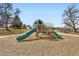 Community playground with slides and climbing structure offering a safe play area surrounded by mature trees at 1801 S Meade St, Denver, CO 80219