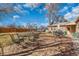 Large backyard with well-maintained grass, patio area with dining sets, and a greenhouse at 1177 Jamaica St, Aurora, CO 80010