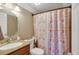 Compact bathroom featuring a pedestal sink and patterned shower curtain at 1177 Jamaica St, Aurora, CO 80010