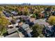 An aerial view of a neighborhood with mature trees and well-maintained homes near the city skyline at 3317 W 37Th Ave, Denver, CO 80211