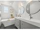 Elegant bathroom with double sinks, round mirrors, and a freestanding soaking tub at 3317 W 37Th Ave, Denver, CO 80211