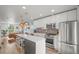 Modern kitchen with white cabinets, stainless steel appliances, and a breakfast bar overlooking living area at 3317 W 37Th Ave, Denver, CO 80211