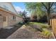 Spacious backyard with brick exterior, small concrete patio, mature trees, and wood fence at 5485 S Jasper Ct, Centennial, CO 80015