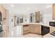 Bright eat-in kitchen with tile flooring, an island with a sink, and views into the living room at 5485 S Jasper Ct, Centennial, CO 80015