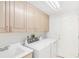 Functional laundry room with upper cabinets, a utility sink, and modern appliances at 5485 S Jasper Ct, Centennial, CO 80015