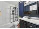 Modern bathroom with a sleek glass-enclosed shower, vanity, and black fixtures against white subway tile at 4878 E Kentucky Ave # B, Denver, CO 80246