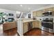 Efficient kitchen with stainless steel appliances, wooden cabinets, and a breakfast bar open to the living area at 4878 E Kentucky Ave # B, Denver, CO 80246