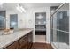 Stylish bathroom features granite countertops, wood cabinets, and a glass shower with views to the bedroom at 10152 Xanadu St, Commerce City, CO 80022