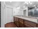 Modern bathroom featuring granite countertops, double sinks, dark wood cabinetry, and sleek gray shower tile at 10152 Xanadu St, Commerce City, CO 80022