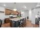 Bright kitchen with granite counters, dark cabinets, and a view into an adjacent living area with ample seating at 10152 Xanadu St, Commerce City, CO 80022