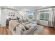 Comfortable living room featuring a large sectional sofa, natural light, and a view of the staircase at 10152 Xanadu St, Commerce City, CO 80022