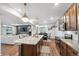 Open-concept living space features hardwood floors, a view of the kitchen, and a comfortable sofa at 10152 Xanadu St, Commerce City, CO 80022