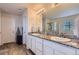 Bathroom featuring double sinks with a large granite countertop and white cabinetry at 4724 S Wenatchee Cir, Aurora, CO 80015