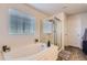 Bright bathroom featuring a soaking tub with tile surround and separate shower at 4724 S Wenatchee Cir, Aurora, CO 80015