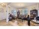 Open living space with a stylish sofa, two chairs, hardwood floors and natural light at 4724 S Wenatchee Cir, Aurora, CO 80015