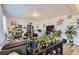 A sunlit living room with a modern sectional sofa, hardwood floors, and numerous plants at 4724 S Wenatchee Cir, Aurora, CO 80015