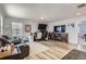 Spacious living room features wood floors, a large TV, a desk, and a comfortable leather couch at 4724 S Wenatchee Cir, Aurora, CO 80015