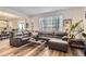 A living room featuring a large gray leather sectional sofa with hardwood floors and open access to the kitchen at 4724 S Wenatchee Cir, Aurora, CO 80015