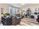 Bright living room with a large window, hardwood floors, and a comfortable dark gray leather sectional sofa at 4724 S Wenatchee Cir, Aurora, CO 80015