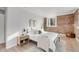 Bright bedroom features an exposed brick wall, hardwood floors, and updated furnishings at 1210 E Colfax Ave # 104, Denver, CO 80218